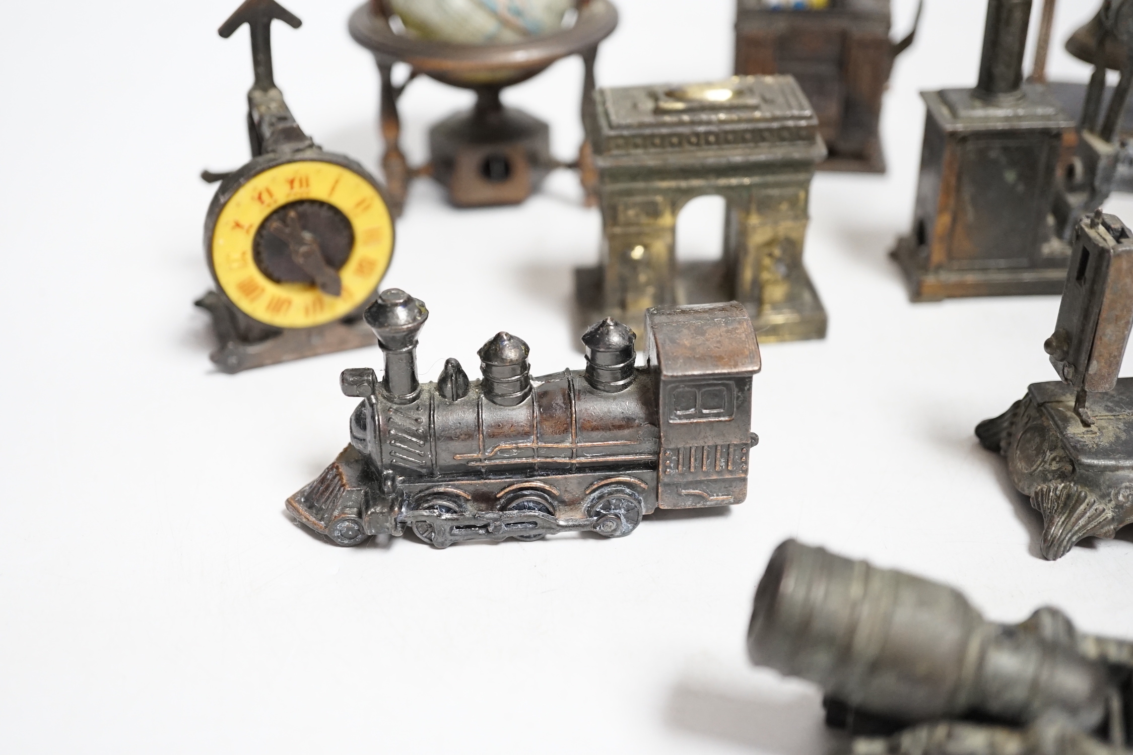 A collection of novelty metal pencil sharpeners and a pair of late Georgian silver plated candlesticks, 20cm